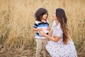 Mother and little handsome baby boy walking in the chickpeas field