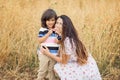 Mother and little handsome baby boy walking in the chickpeas field