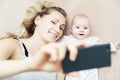 Mother and little infant baby taking selfie with phone