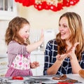 Mother and little kid girl baking gingerbread cookies for Christ Royalty Free Stock Photo