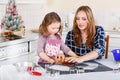 Mother and little kid girl baking gingerbread cookies for Christ Royalty Free Stock Photo