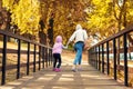 Mother and little preschooler daughter having fun and fooling around in autumn city park. Mom and child walking and jumping on Royalty Free Stock Photo