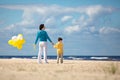 Mother and little son with ballons on the beach