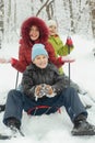 Mother, little son and daughter ride on sled