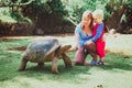 Mother and little son feeding giant turtle