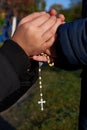 Mother and little son hold each other`s hand with a rosary