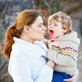 Mother and little son in park or forest, outdoors. Hugging and having fun together. Happy toddler boy and young mum, kid Royalty Free Stock Photo