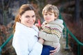 Mother and little son in park or forest, outdoors. Hugging and having fun together. Happy toddler boy and young mum, kid Royalty Free Stock Photo