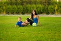 Mother and little son playing ball on grass in park Royalty Free Stock Photo