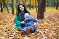 Mother with little son plays in autumn park Royalty Free Stock Photo