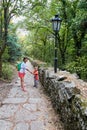 Mother and little son are walking along the green park alley. Royalty Free Stock Photo