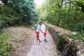 Mother and little son are walking along the green park alley. Royalty Free Stock Photo