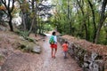 Mother and little son are walking along the green park alley. Royalty Free Stock Photo