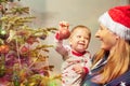 Mother and little toddler decorate Christmas tree