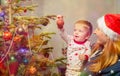 Mother and little toddler decorate Christmas tree