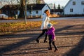 Mother and little toddler girl walking together on the way at the sunset. Mother and daughter are walking in the park in the eveni Royalty Free Stock Photo