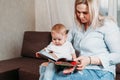 Mother looking at book with her child son at home Royalty Free Stock Photo