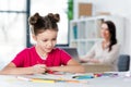 Mother looking at cute little girl drawing at table Royalty Free Stock Photo