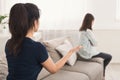 Mother looking at daughter who sitting sadly on sofa Royalty Free Stock Photo