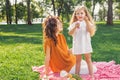 Mother looking her daughter blowing sopa bubbles in the park Royalty Free Stock Photo