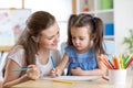 Mother looking how her child daughter drawing a picture Royalty Free Stock Photo