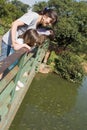 Mother Looking into Pond with Two Daughters Royalty Free Stock Photo