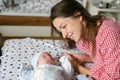 Mother looks at her child. Young mother looking on her newborn baby. Beautiful mom lying at bed with a cute sleeping new born Royalty Free Stock Photo