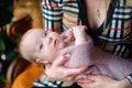 Mother with love and tenderness holds on hands of the newborn baby, the kid with curiosity looks in the camera. Motherhood, happy