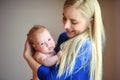 Mother with love and tenderness holds on hands of the newborn baby, smiles and considers the baby.