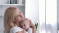 Mother love, young parent tenderly holds his newborn girl then hugs and kisses on kitchen