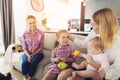 Mother with Lovely Kids Sits on Couch near Nanny