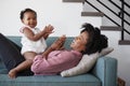 Mother Lying On Sofa At Home Playing Clapping Game With Baby Daughter Royalty Free Stock Photo