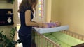 Mother make therapeutical massage for child lie on swaddle board