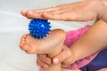 Mother makes foot massage with blue massage ball Royalty Free Stock Photo