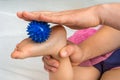 Mother makes foot massage with blue massage ball
