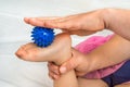 Mother makes foot massage with blue massage ball