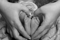 Mother makes a heart around her newborn baby boy`s little feet