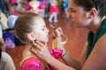 Young mother makes a make-up for her daughter before the concert show Royalty Free Stock Photo