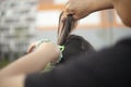 Mother makes ponytail out of her daughter`s hair. Creating hairstyle for child. Elastic band for thick hair. Care for preschooler Royalty Free Stock Photo