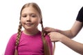 Mother is making of braids on little daughter`s head. Hairdresser is braiding the hair on a young girl. Getting ready for school Royalty Free Stock Photo