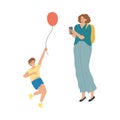 Mother making photo of her smiling son with balloon during summer festival