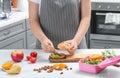 Mother making sandwich for school lunch at table in kitchen Royalty Free Stock Photo