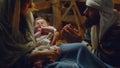 Mary and Joseph with baby Jesus resting in dim barn