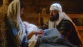 Mary and Joseph with baby Jesus resting in dim barn