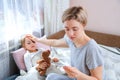 Mother measuring temperature of her ill child. Sick child with high fever laying in bed with teddybear. Fever Concept Royalty Free Stock Photo