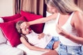 Mother measuring temperature of her ill kid. Sick child with high fever laying in bed and mother holding thermometer. Healthcare Royalty Free Stock Photo