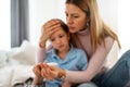 Mother measuring temperature of her ill kid. Sick child with high fever, mother holding thermometer. Royalty Free Stock Photo