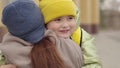 mother meets child with backpack from school, kid with school bag hugs a mother in the schoolyard, child's love for