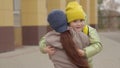 mother meets child with backpack from school, kid with school bag hugs a mother in the schoolyard, child& x27;s love for