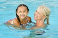 Mother and mixed race girl playing in pool Royalty Free Stock Photo